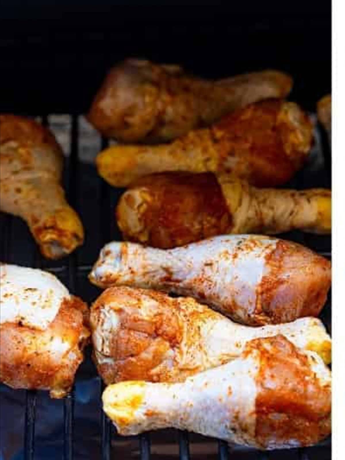 Seasoned drumsticks on the smoker for smoked chicken legs.