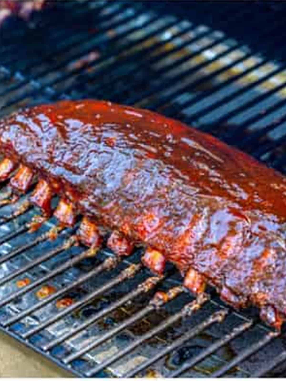 Finished smoked ribs with caramelized barbecue sauce on the grill.