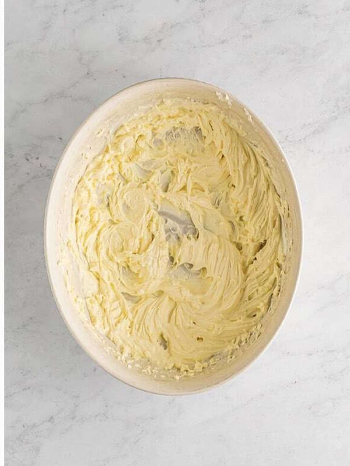 Cream cheese, mayonnaise, and sour cream whipped smooth in a bowl for smoked salmon dip.