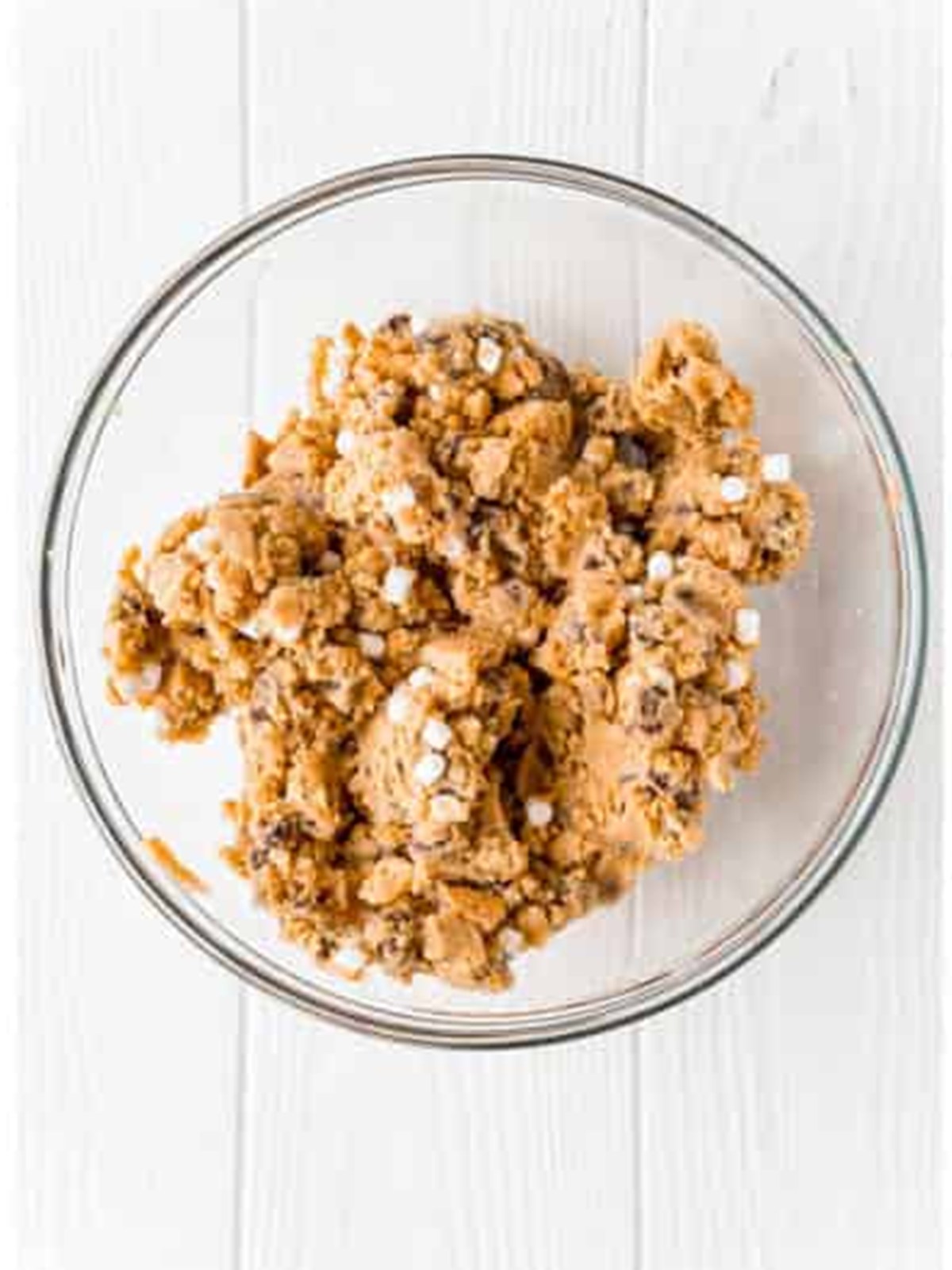 Crushed graham crackers in a glass bowl for s'mores cookies.