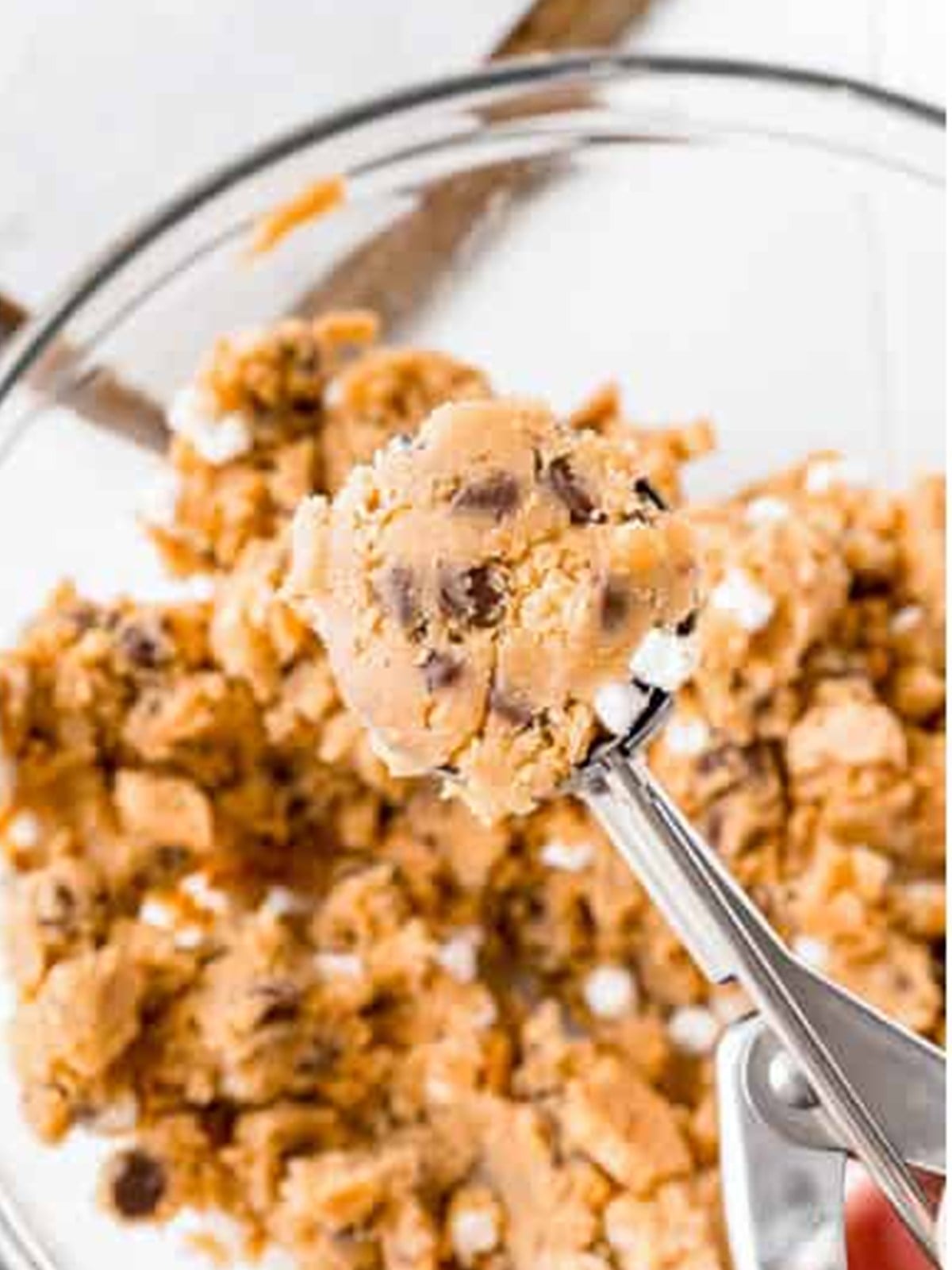 Cookie dough mixed with crushed grahams and mini marshmallows in a stand mixer bowl.