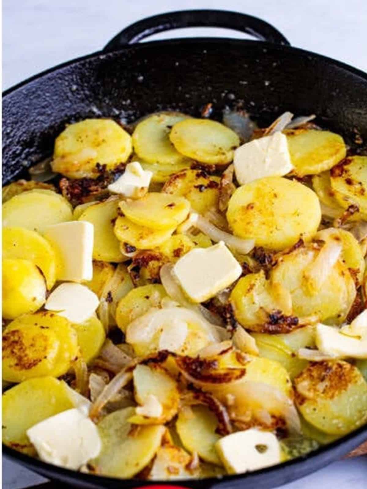 Butter dotted over the potatoes in a cast iron skillet before covering for smothered potatoes.
