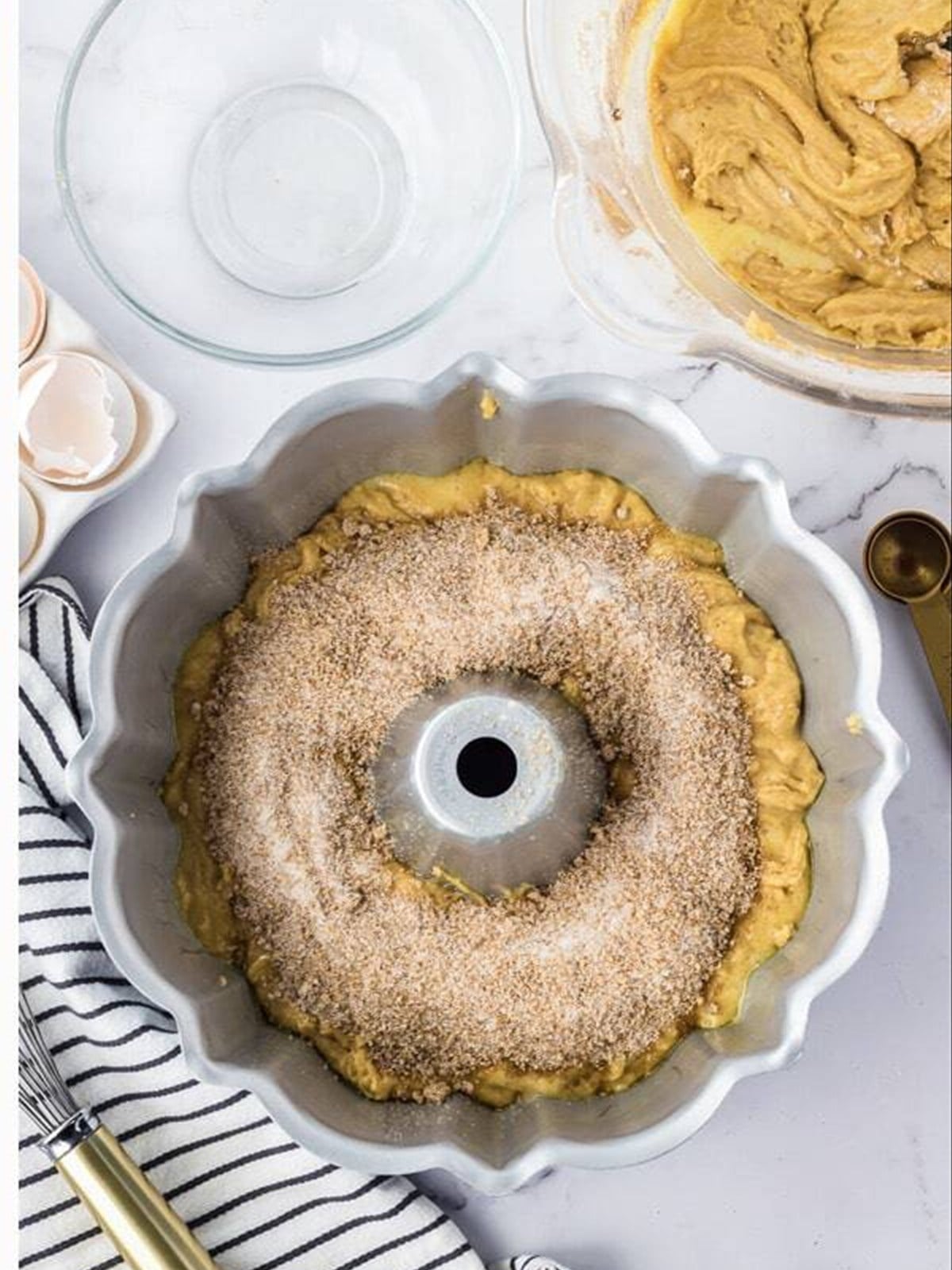 Cinnamon sugar sprinkled over batter in a Bundt pan.