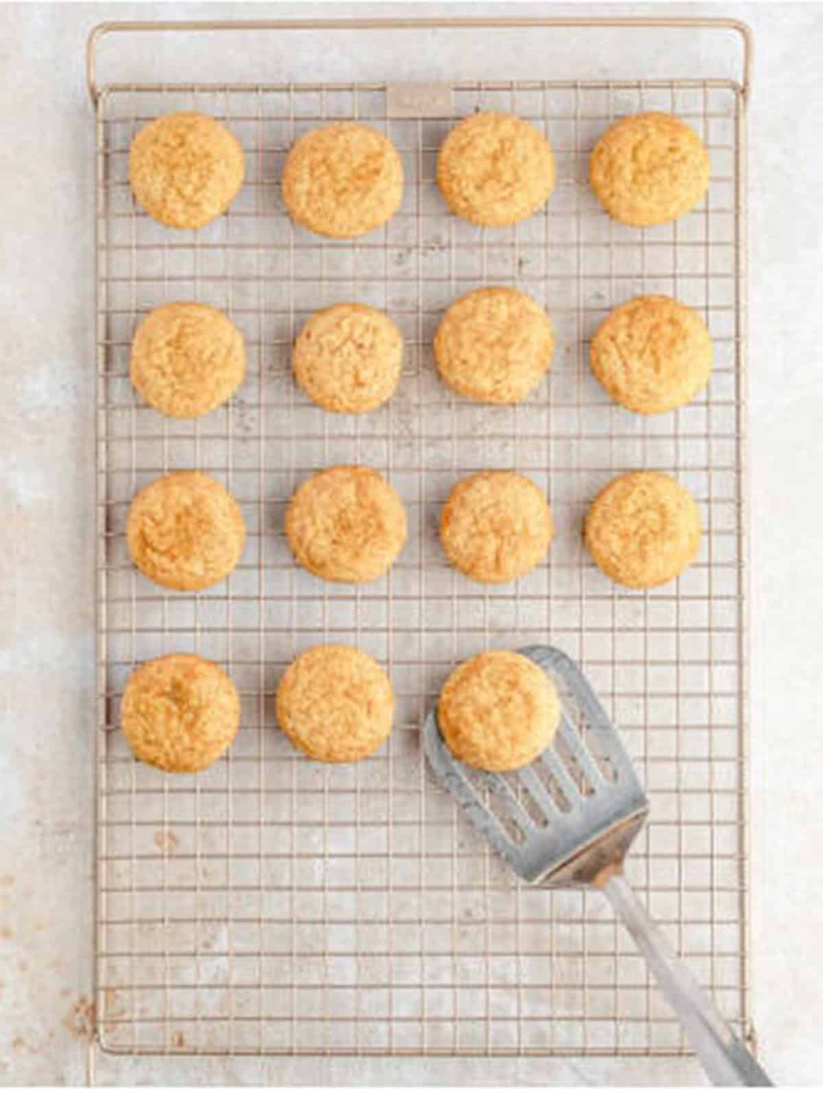 Baked snickerdoodle cookies cooling on a wire rack.