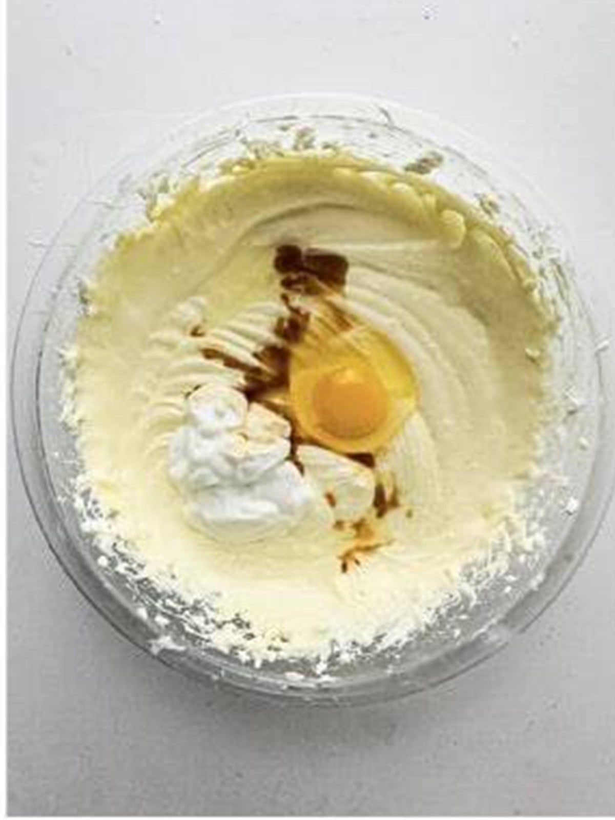 Cream cheese filling with egg, sour cream, and vanilla being blended.