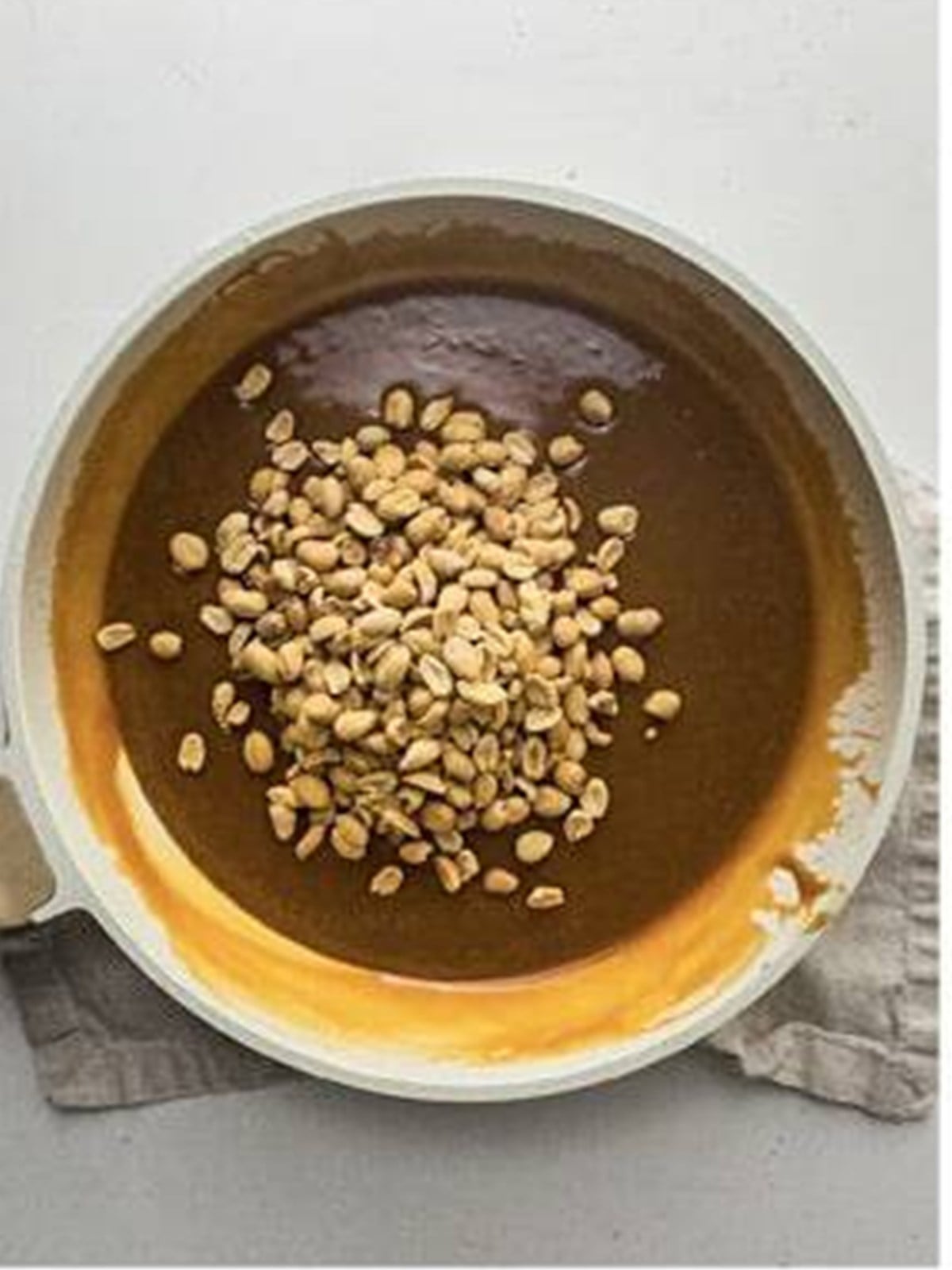Caramel and salted peanuts poured over the baked Snickers cheesecake.