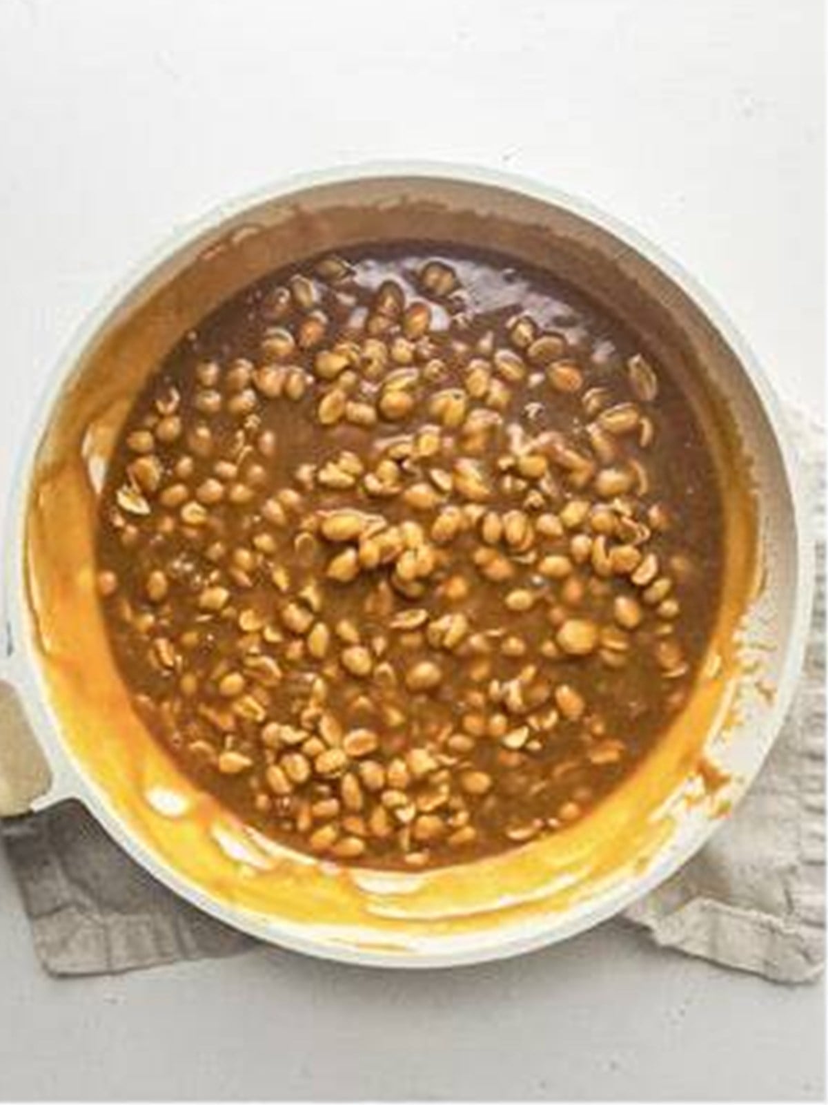 Caramel peanut layer spread evenly over the cheesecake.
