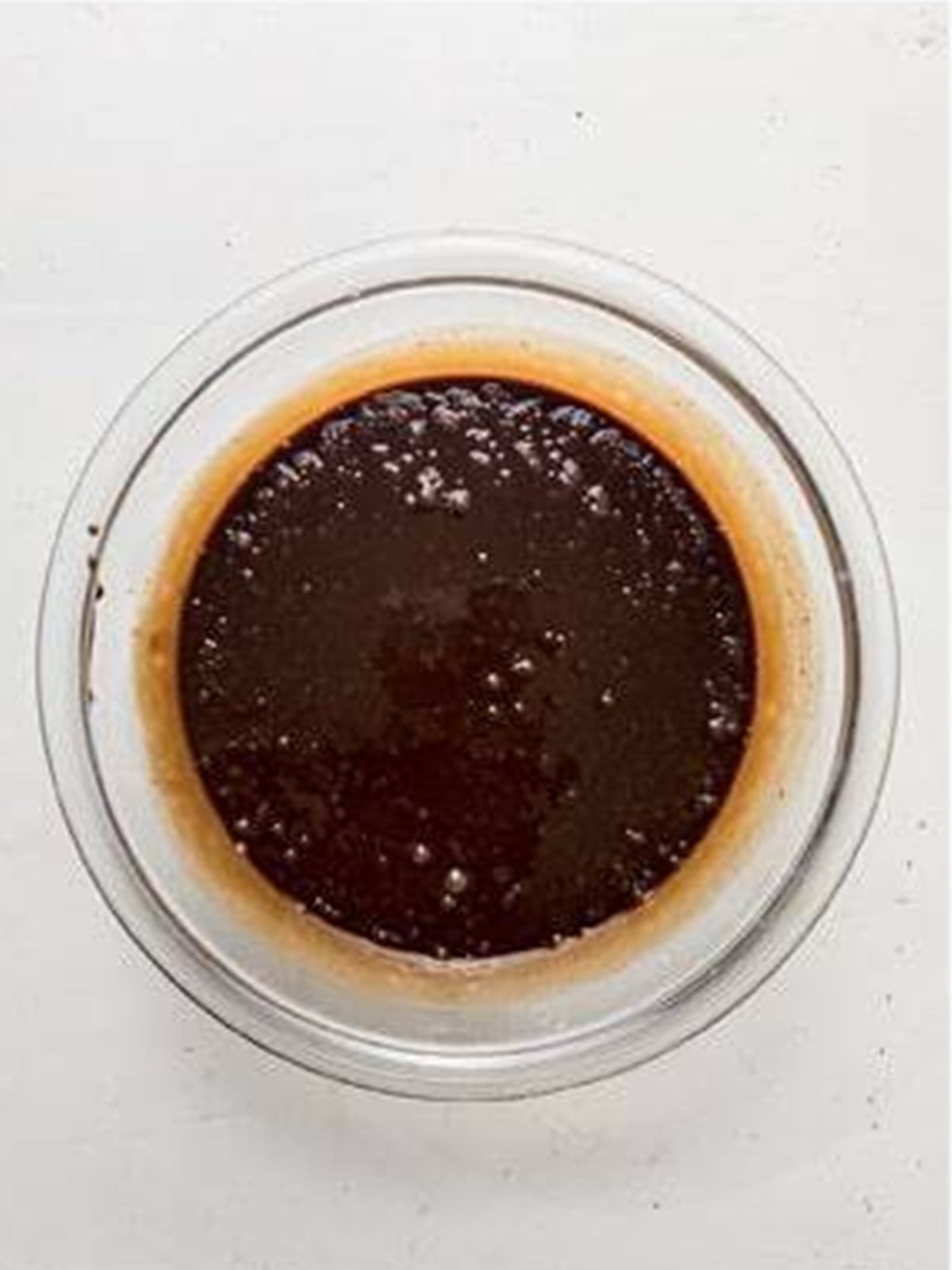 Smooth milk chocolate ganache stirred together in a bowl.