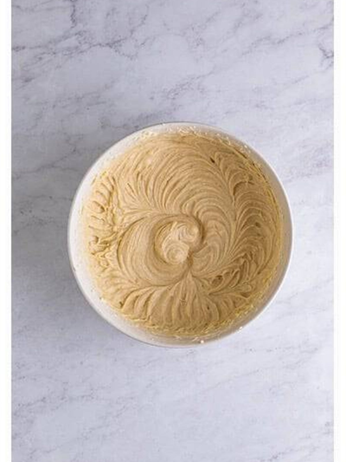 Cream cheese, sugar, and vanilla beaten smooth in a bowl for sopapilla cheesecake filling.