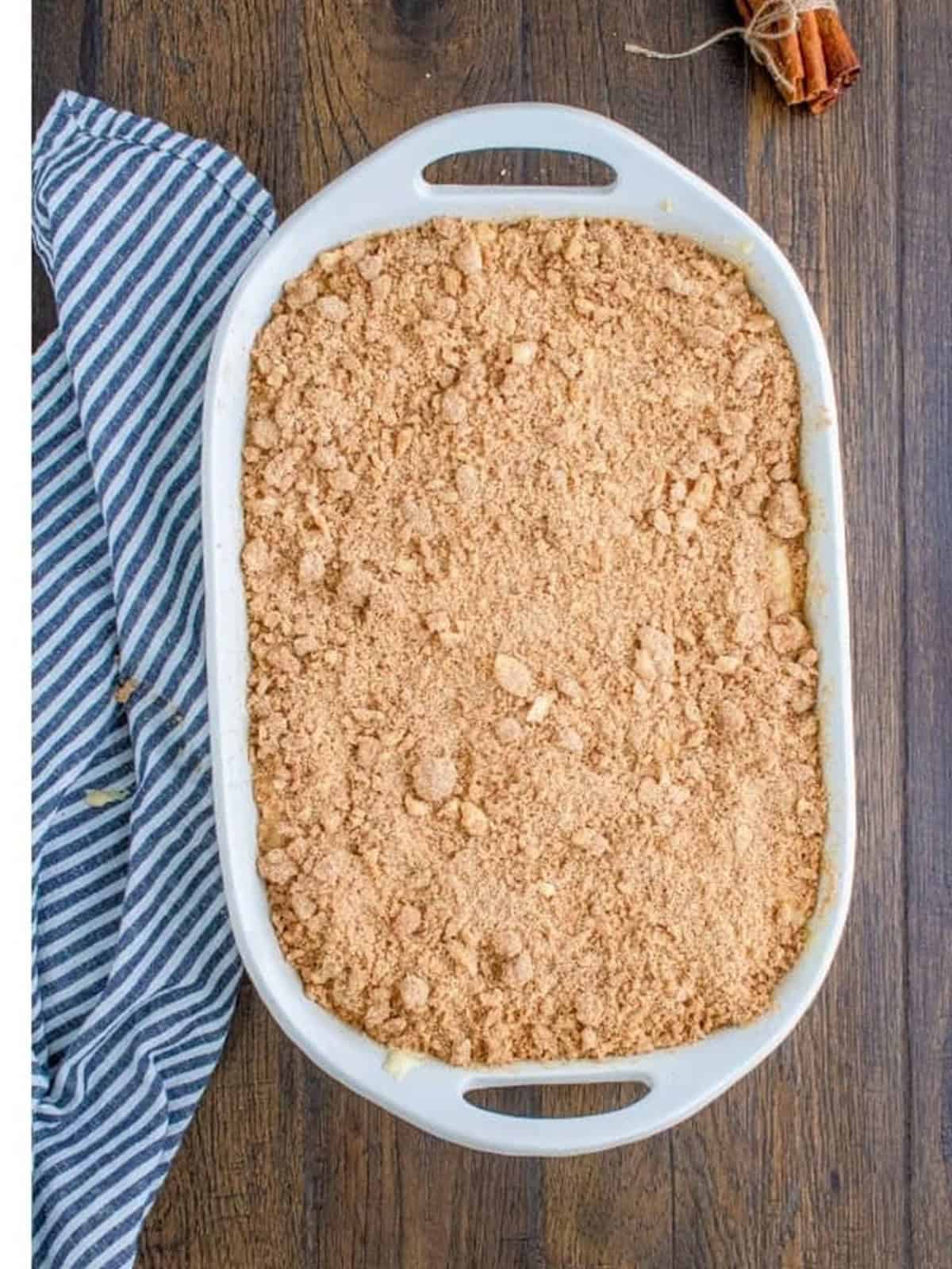 Cinnamon crumble layered over the batter in the sour cream coffee cake baking dish.