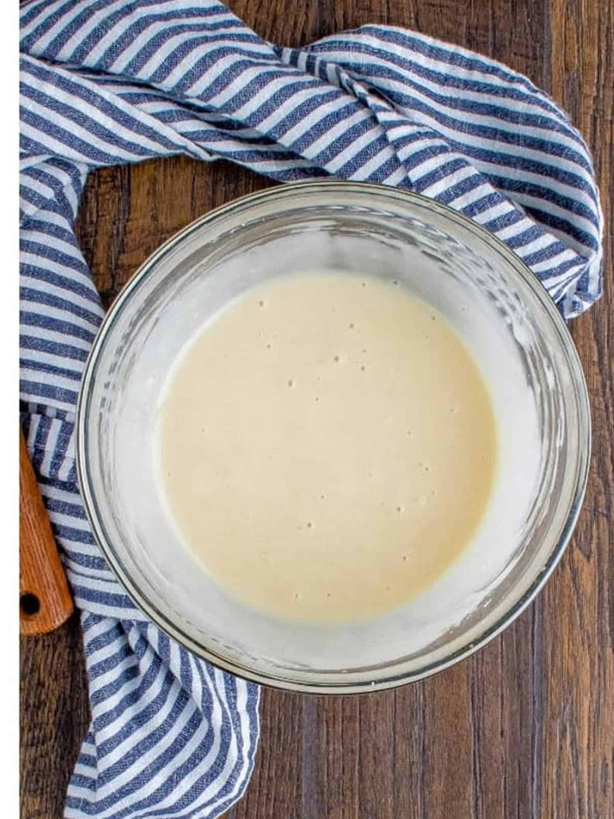Sour cream glaze whisked smooth in a glass bowl for the coffee cake.