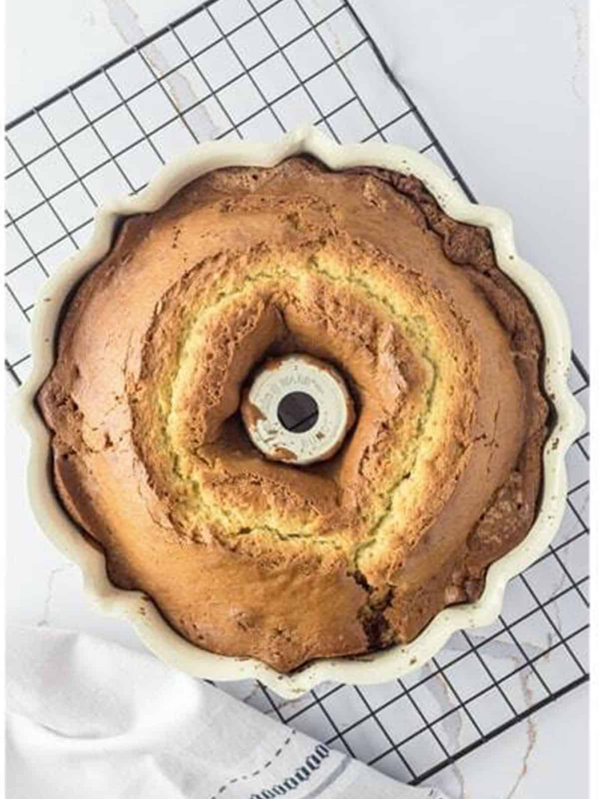 Baked sour cream coffee cake cooling in the bundt pan on a wire rack.