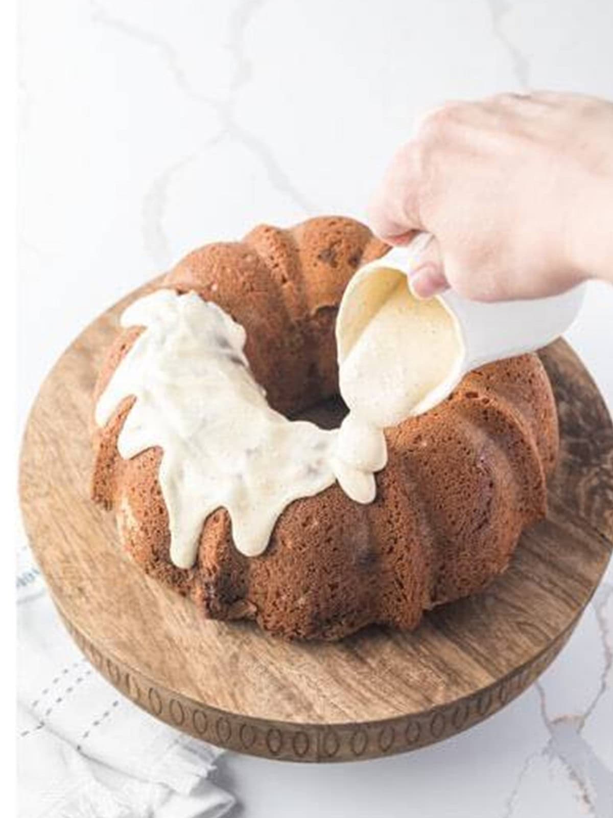 Cream cheese glaze poured over the cooled sour cream coffee cake bundt.