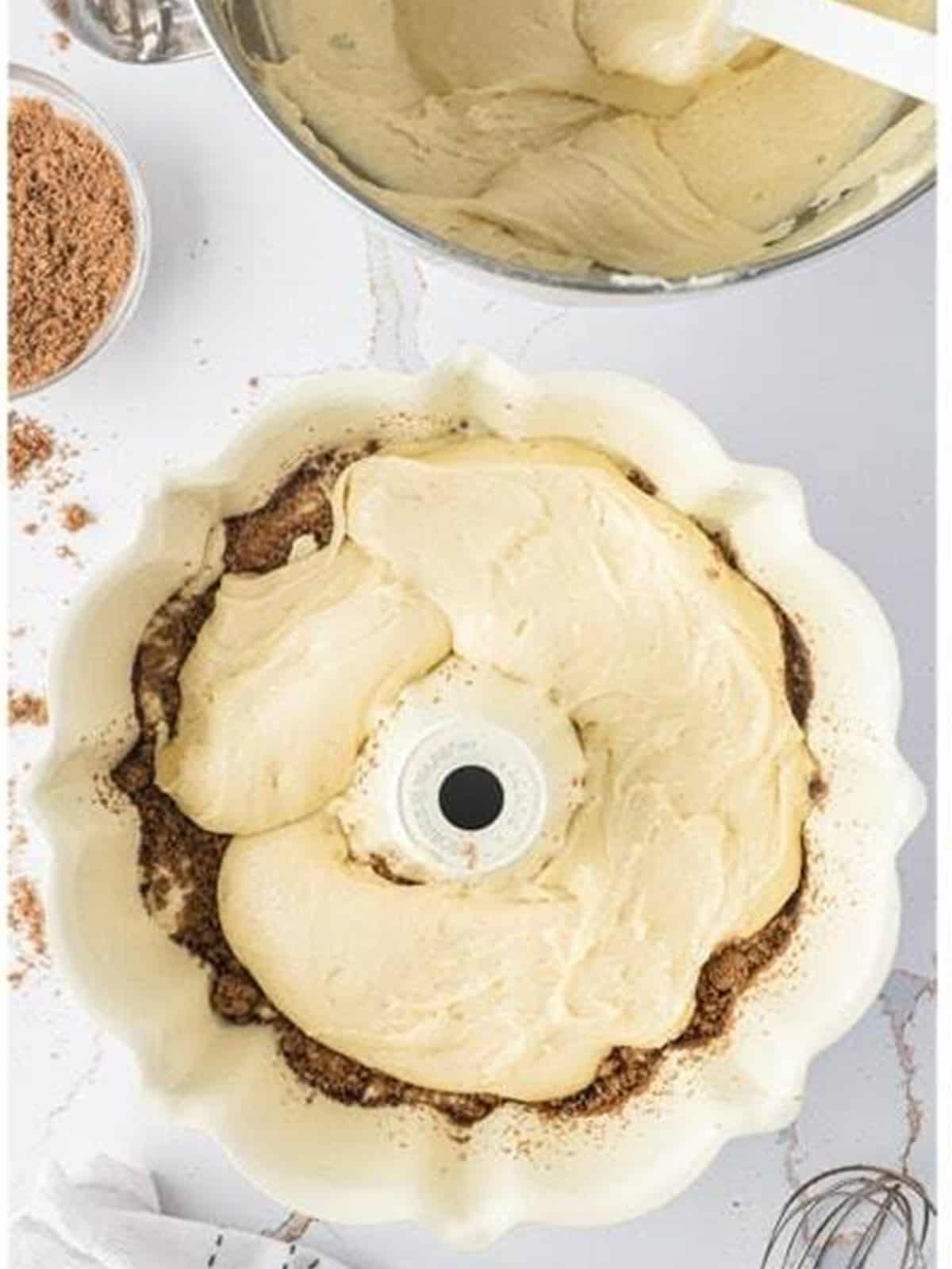 Second layer of batter smoothed over the cinnamon filling in the bundt pan.
