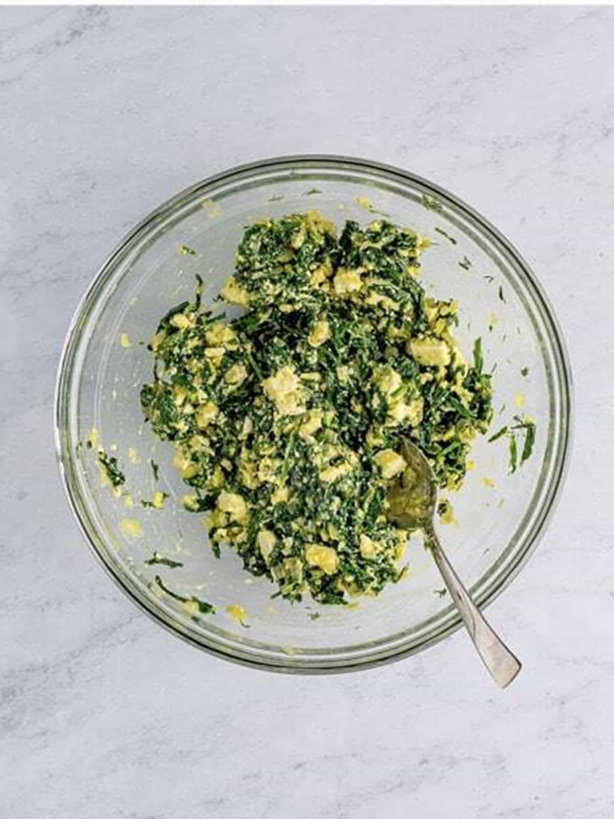 Spinach, feta, Parmesan, egg, and dill mixed into the spanakopita filling.