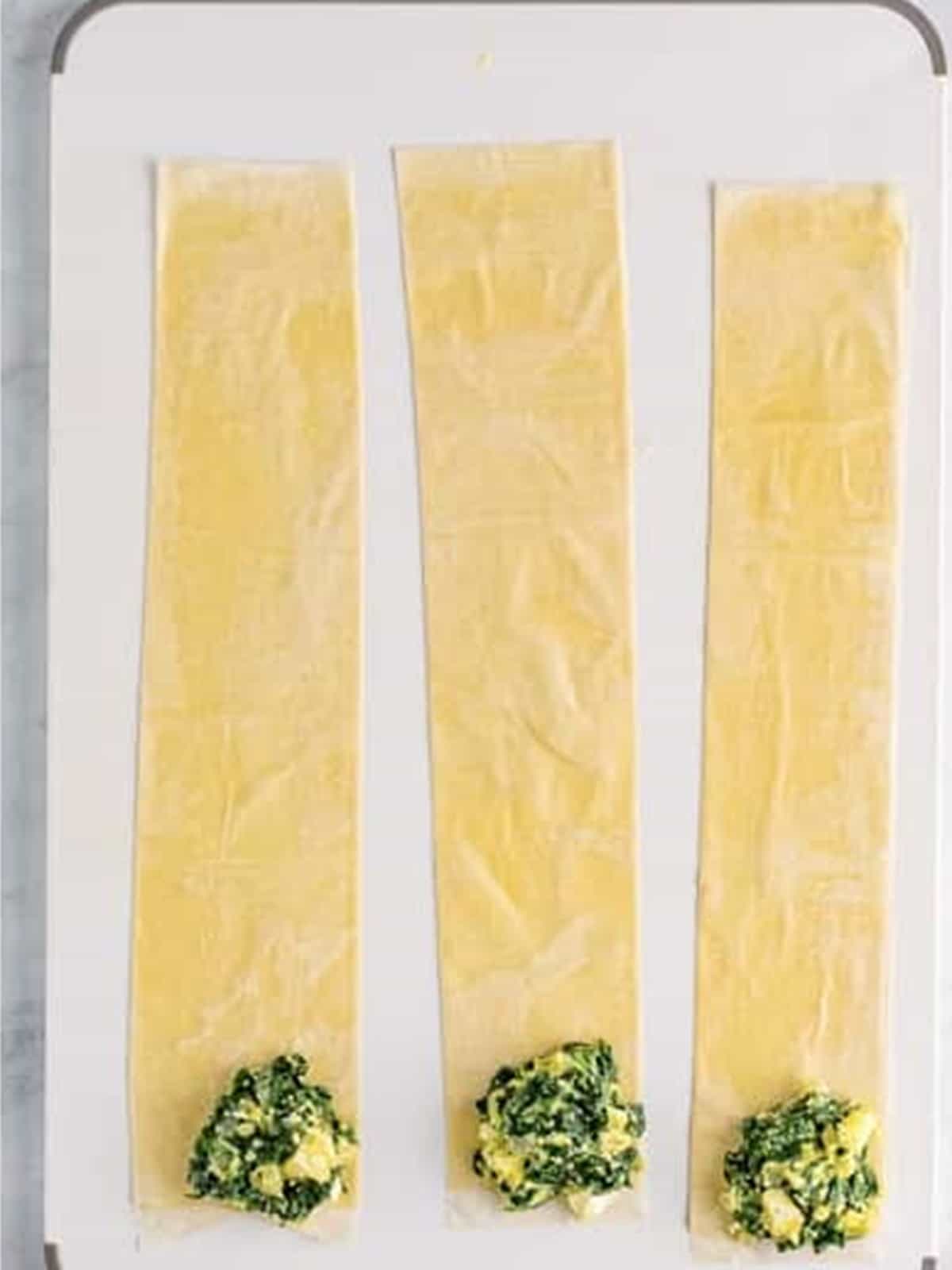 Spinach and feta filling placed on the corner of each phyllo strip.