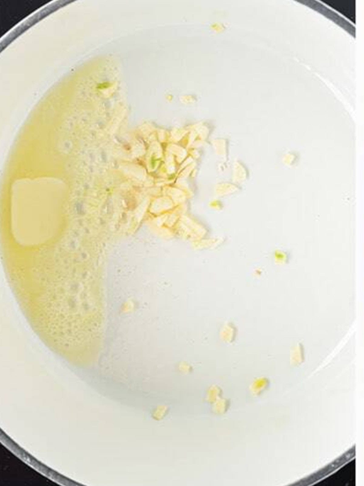 Cooking butter and minced garlic in a skillet for Spanish Rice.