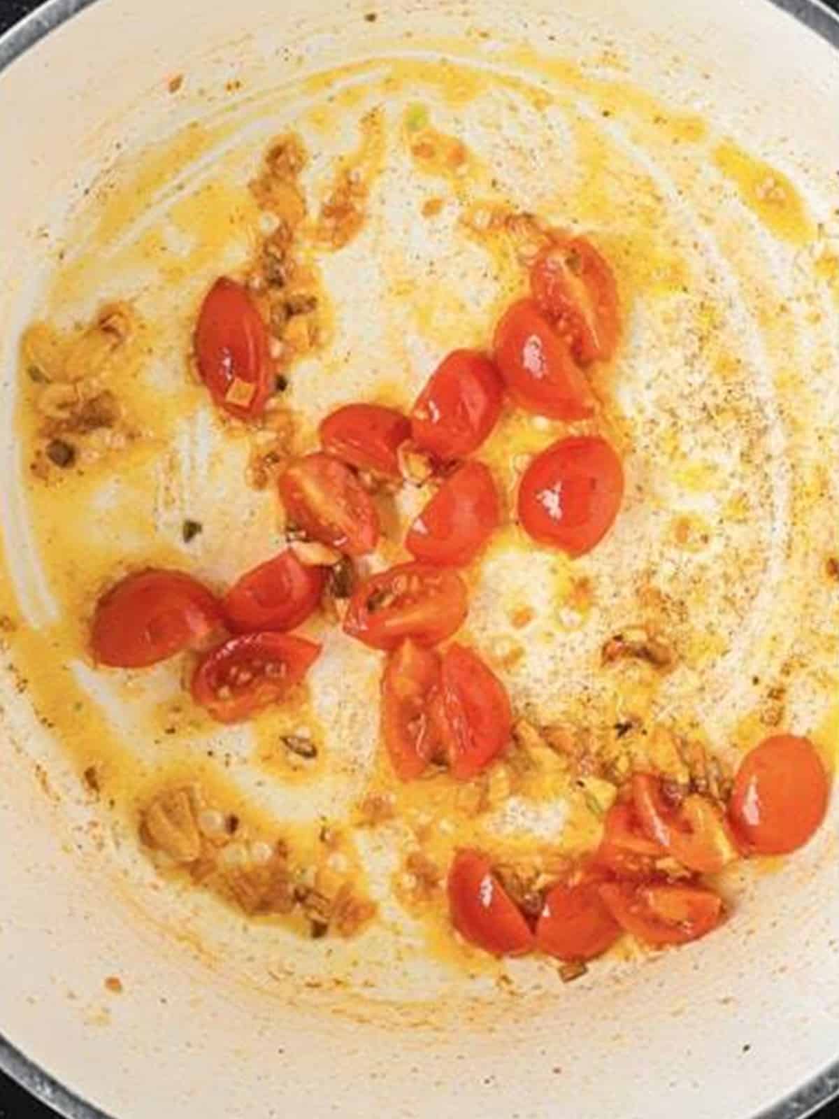 Sauteing cherry tomatoes in the garlic butter for Spanish Rice.
