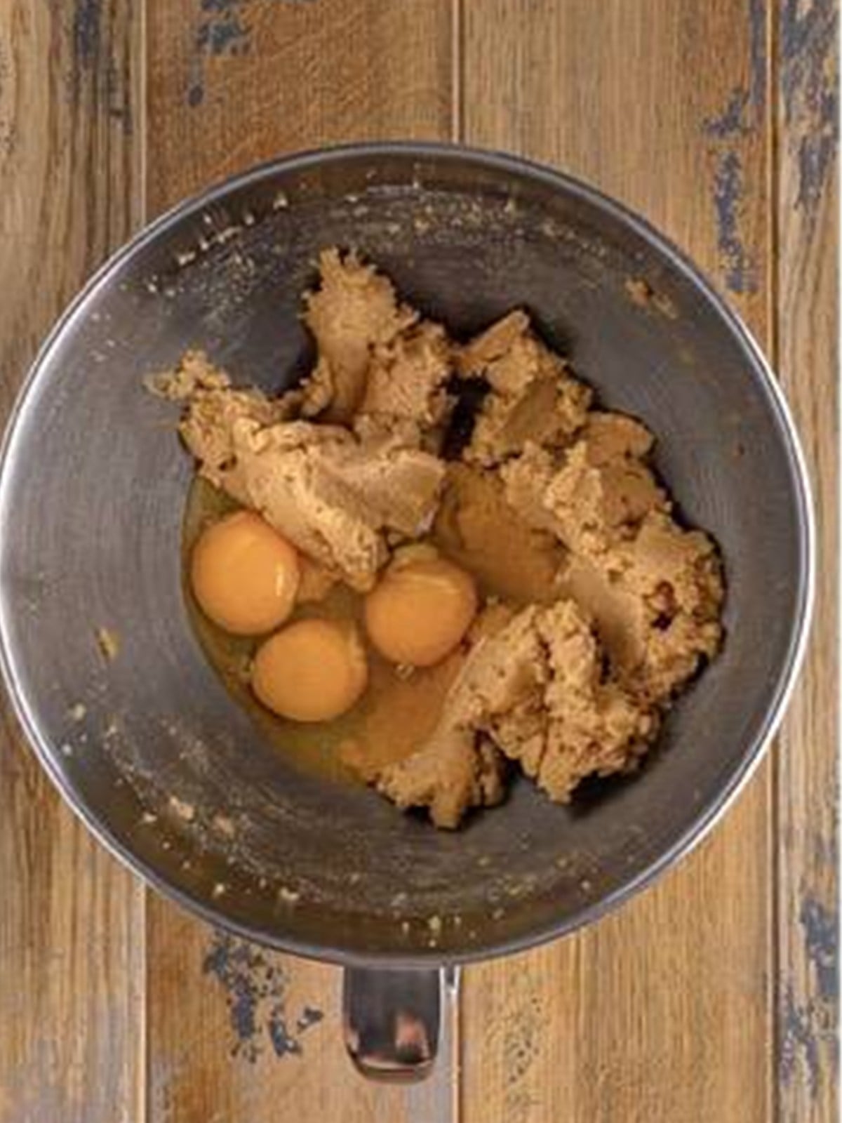 Butter, brown sugar, and eggs being creamed in a stand mixer.