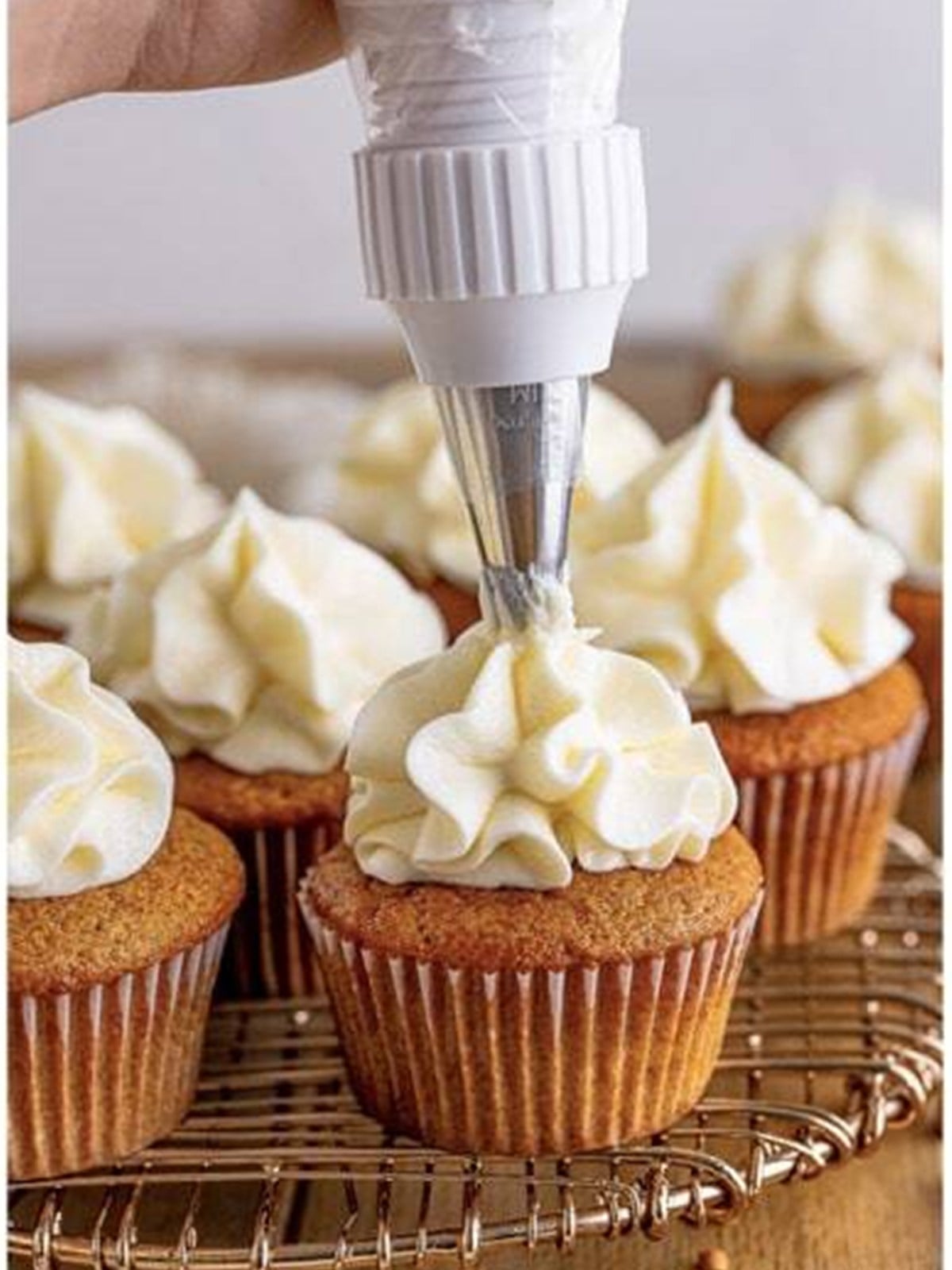 Cream cheese frosting piped onto cooled spice cupcakes.