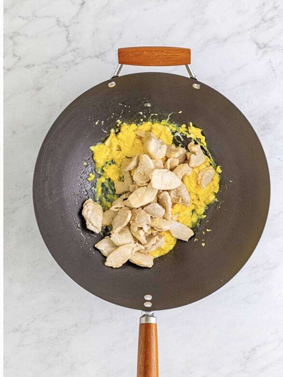 Cooked chicken mixed back into the scrambled eggs in the wok.