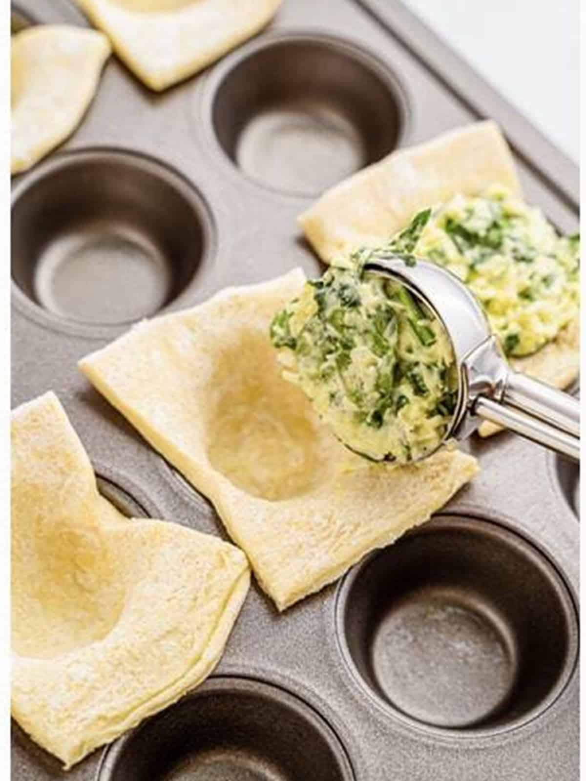 Spinach filling scooped into each puff pastry square with a small cookie scoop.