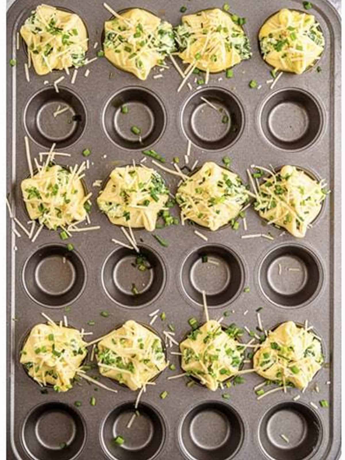 Folded spinach puffs brushed with egg wash and topped with scallions and Parmesan.