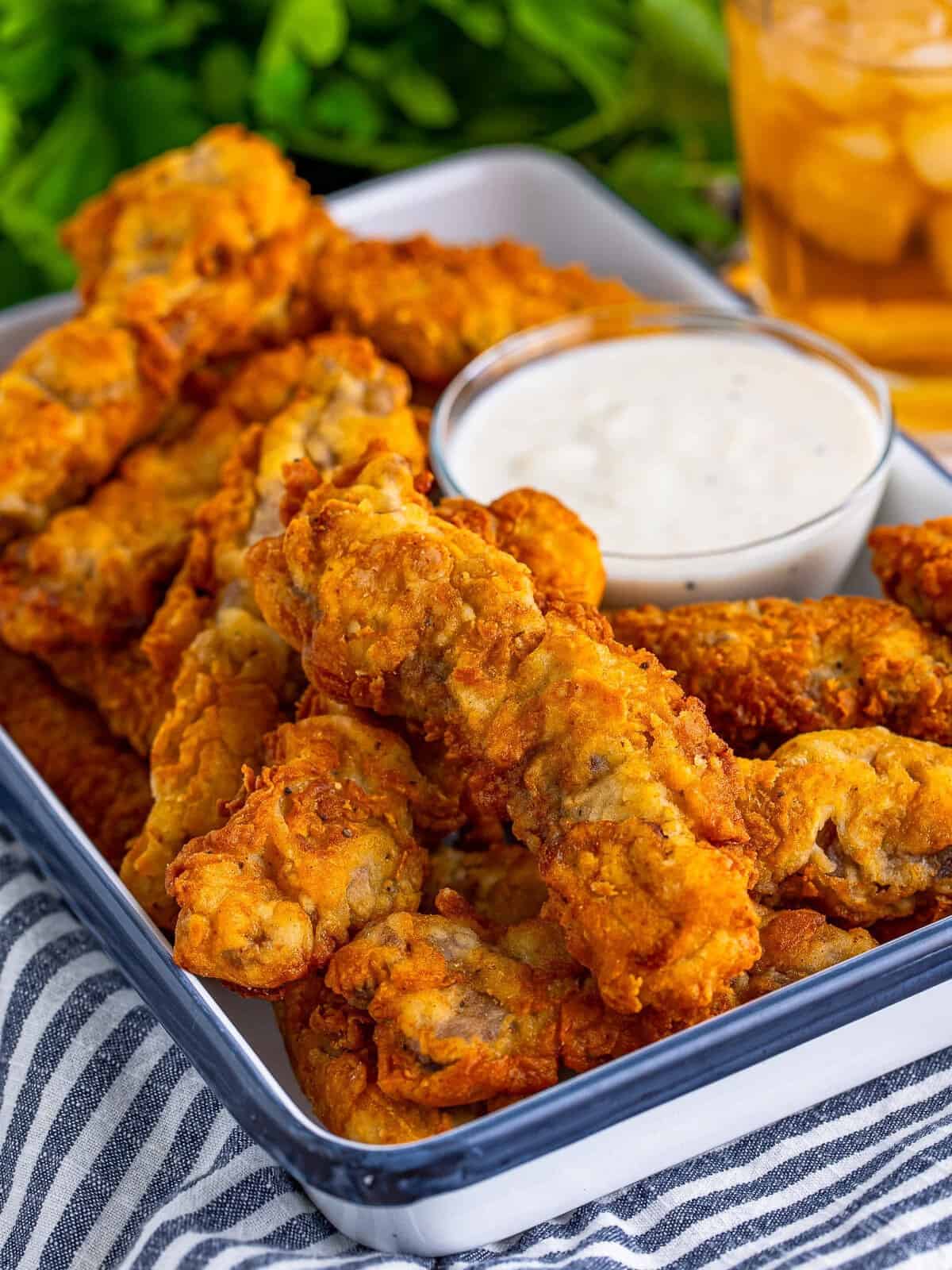 Golden crispy chicken fried steak fingers on a sheet tray after frying.
