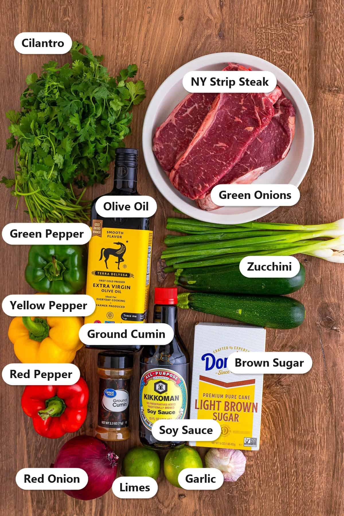 Labeled ingredients for steak kabobs including NY strip steak, peppers, zucchini, soy sauce, and lime.