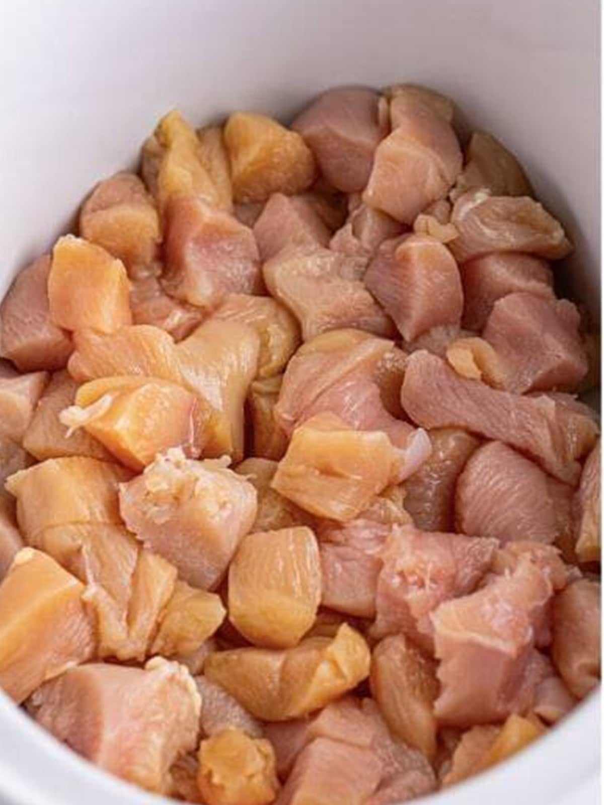 Bite-sized chicken pieces in a slow cooker for Mississippi chicken.