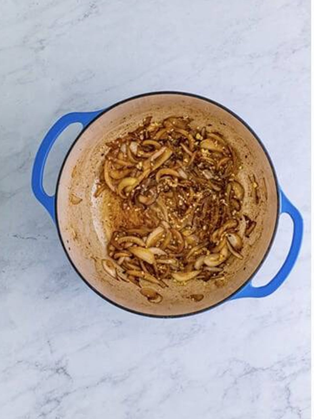 Sliced onions cooked in butter in a Dutch oven for gravy.
