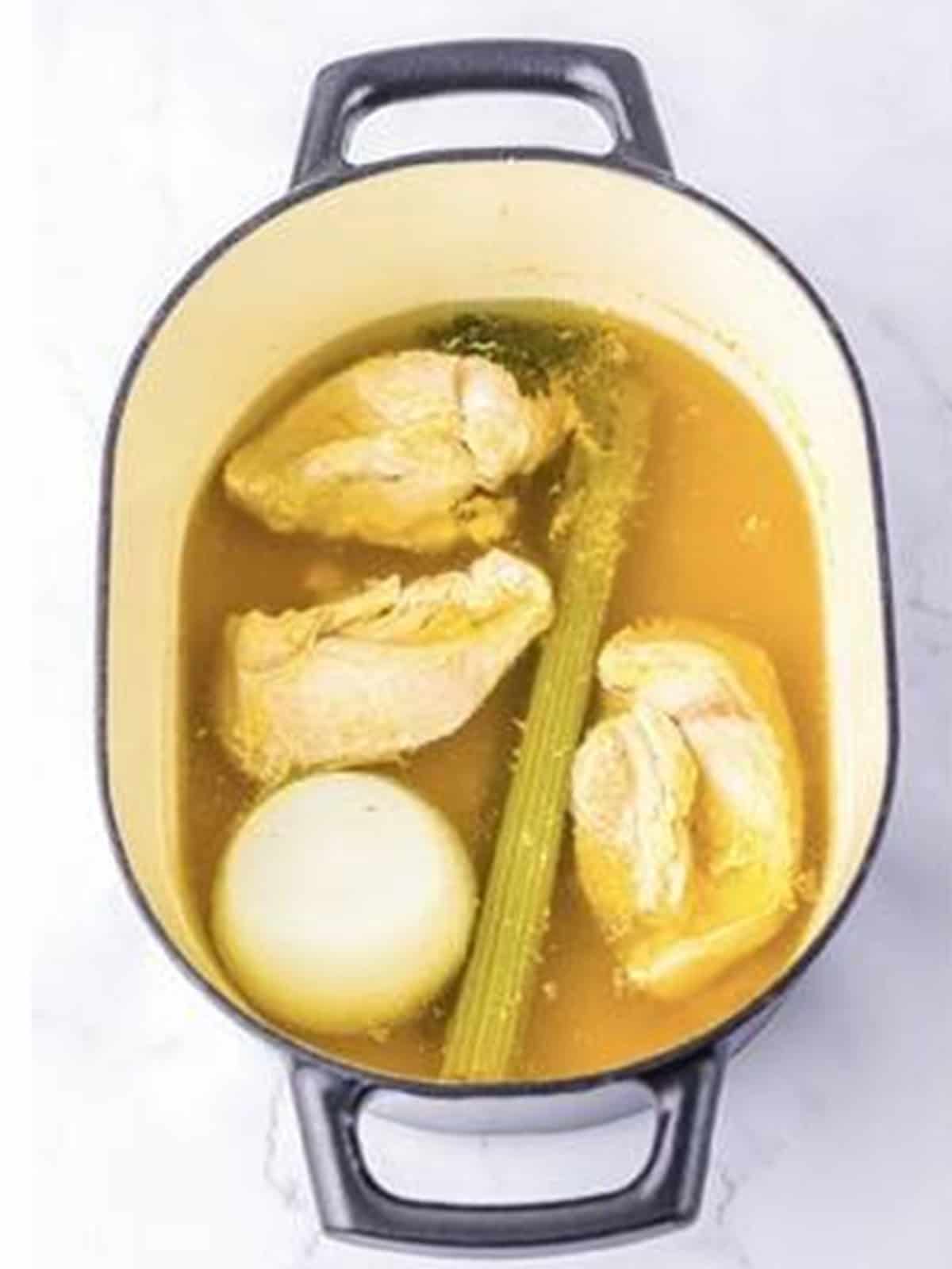 Cooked chicken in stock with onion and celery before removing.