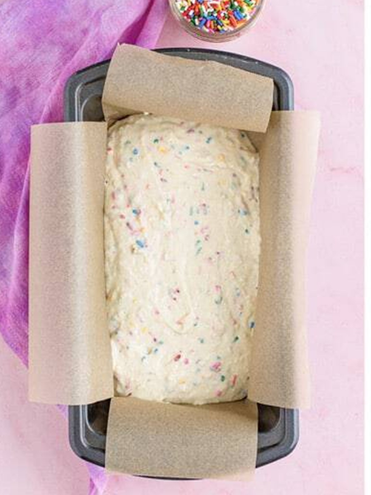 Ice cream bread batter spread into a parchment-lined loaf pan.