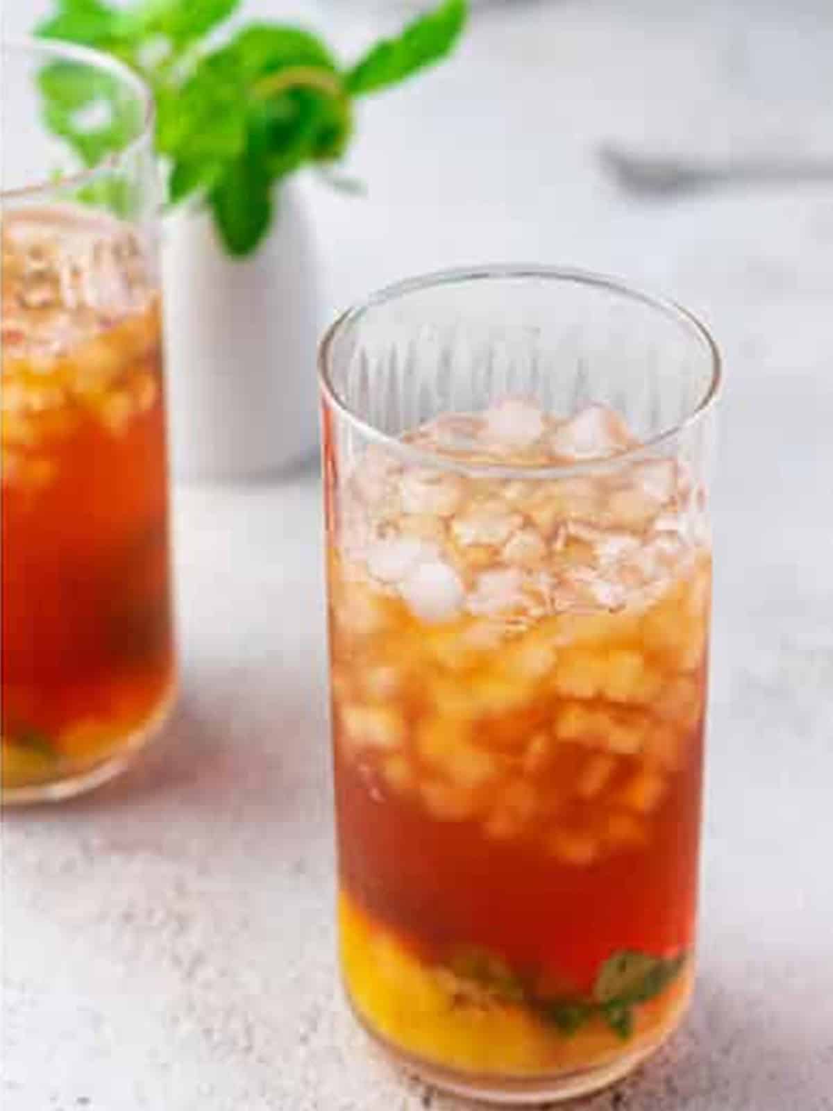 Glass of peach tea over ice before adding ice cream.