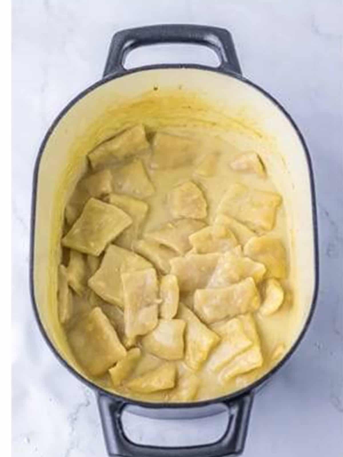 Dumpling squares added to simmering stock to cook.