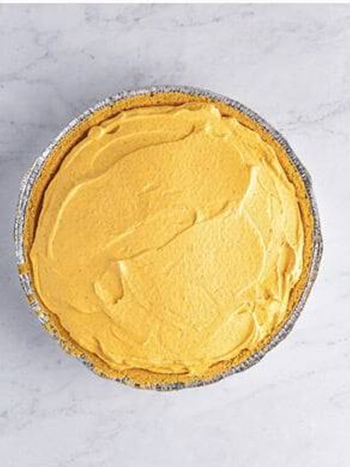 No bake pumpkin cheesecake filling smoothed into a graham cracker crust.
