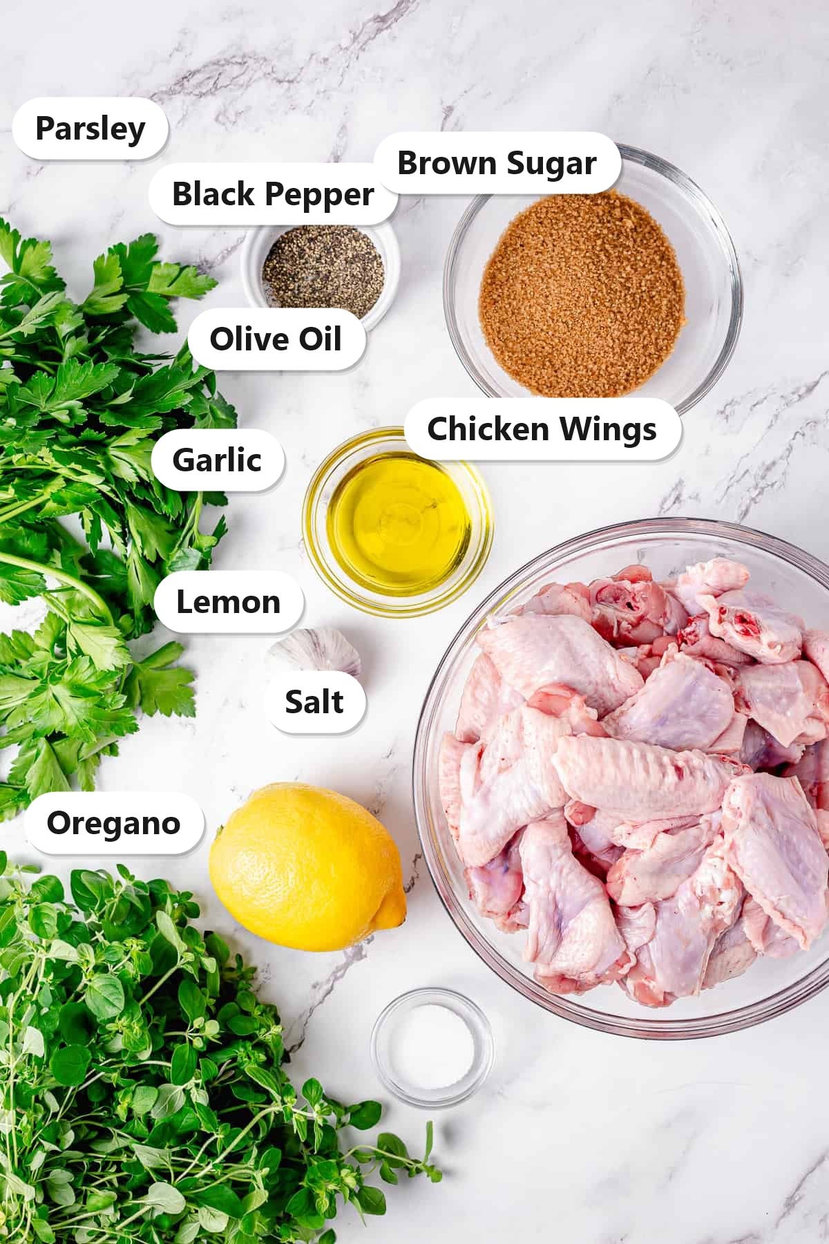 Labeled ingredients for sticky grilled chicken wings including chicken wings, brown sugar, lemon, garlic, parsley, and oregano.