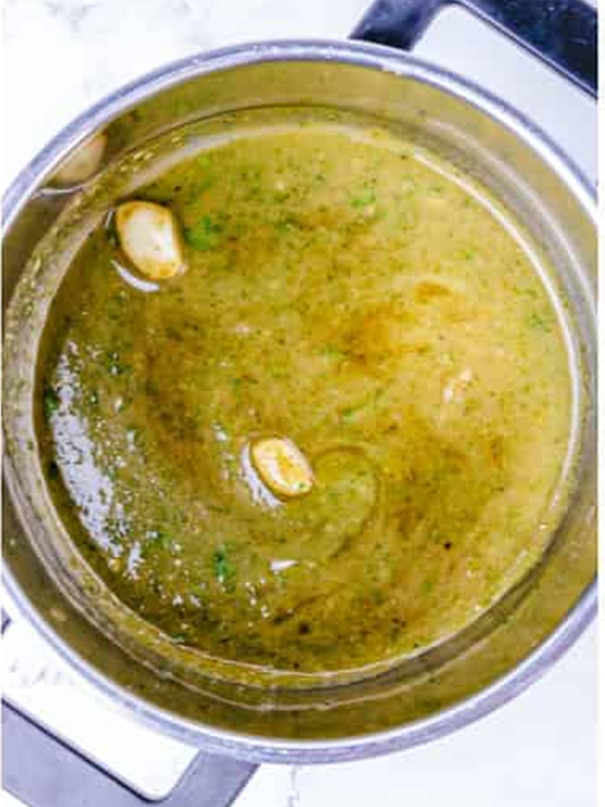 Reserved wing marinade simmering in a saucepan for basting.