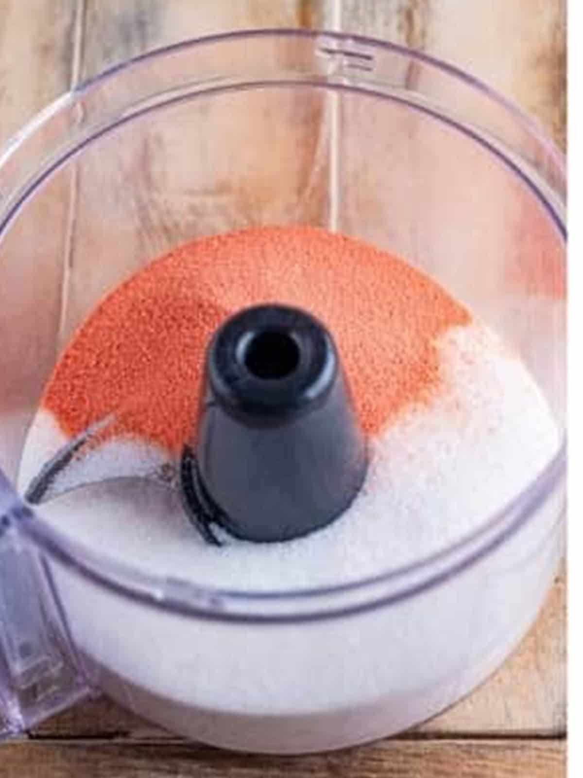 Strawberry jello and sugar in a food processor for strawberry angel food cake.