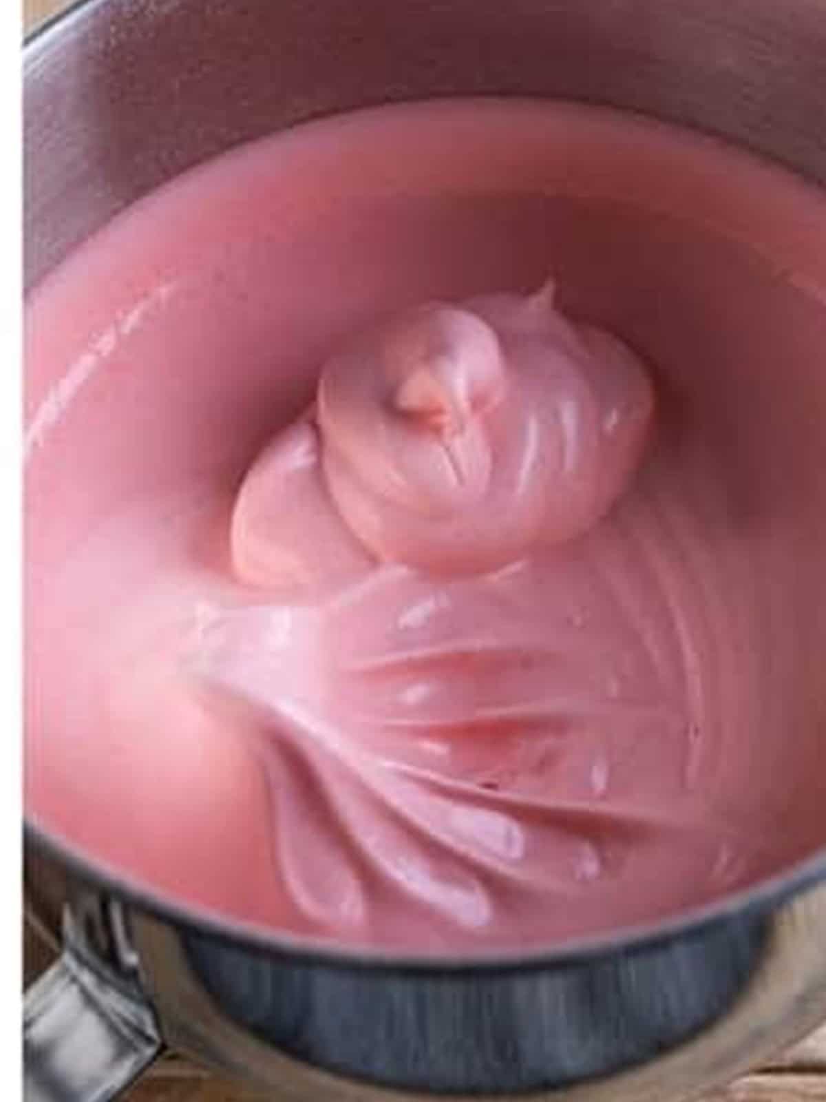 Egg whites whipped to soft peaks in a stand mixer bowl.