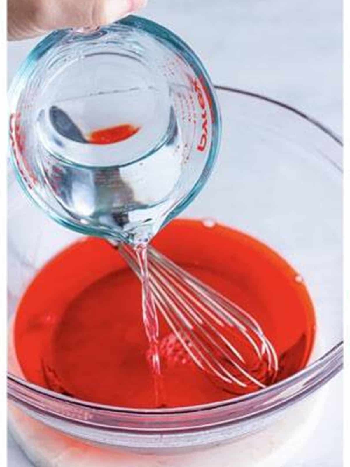 Cold water, vodka, and cream whisked into the strawberry jello.