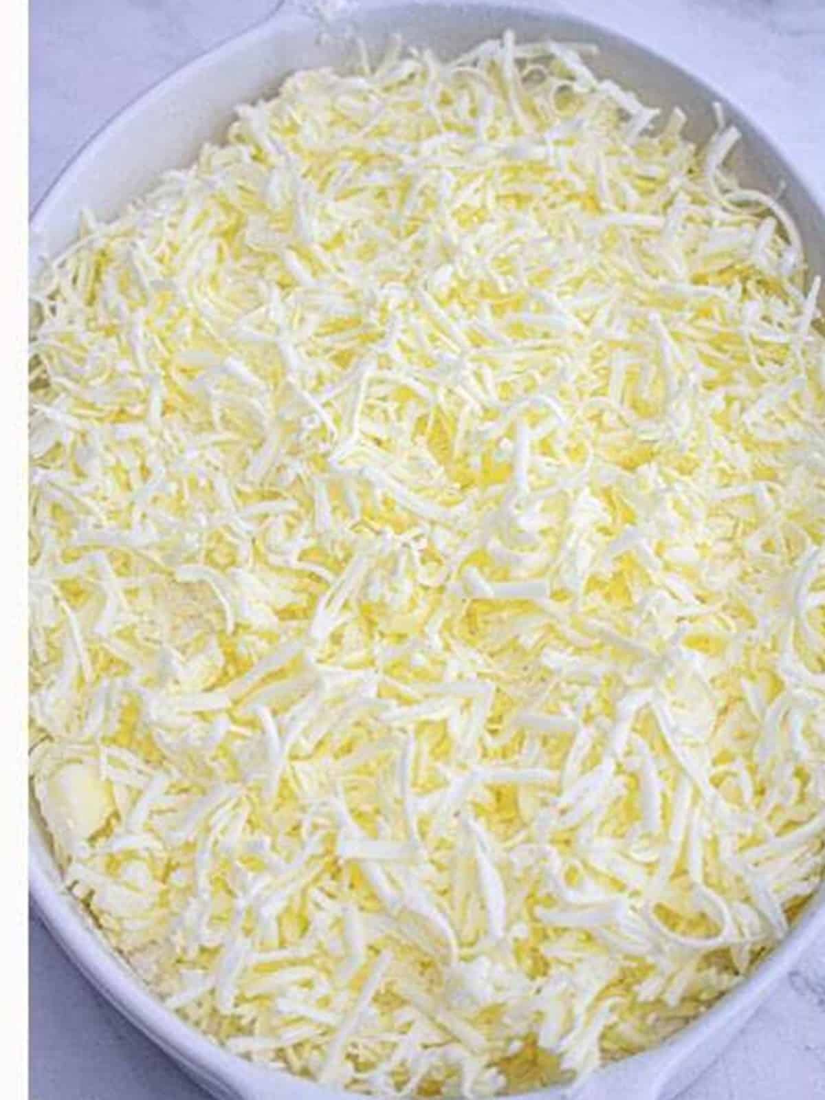 Grated butter covering the top of the strawberry cheesecake dump cake before baking.