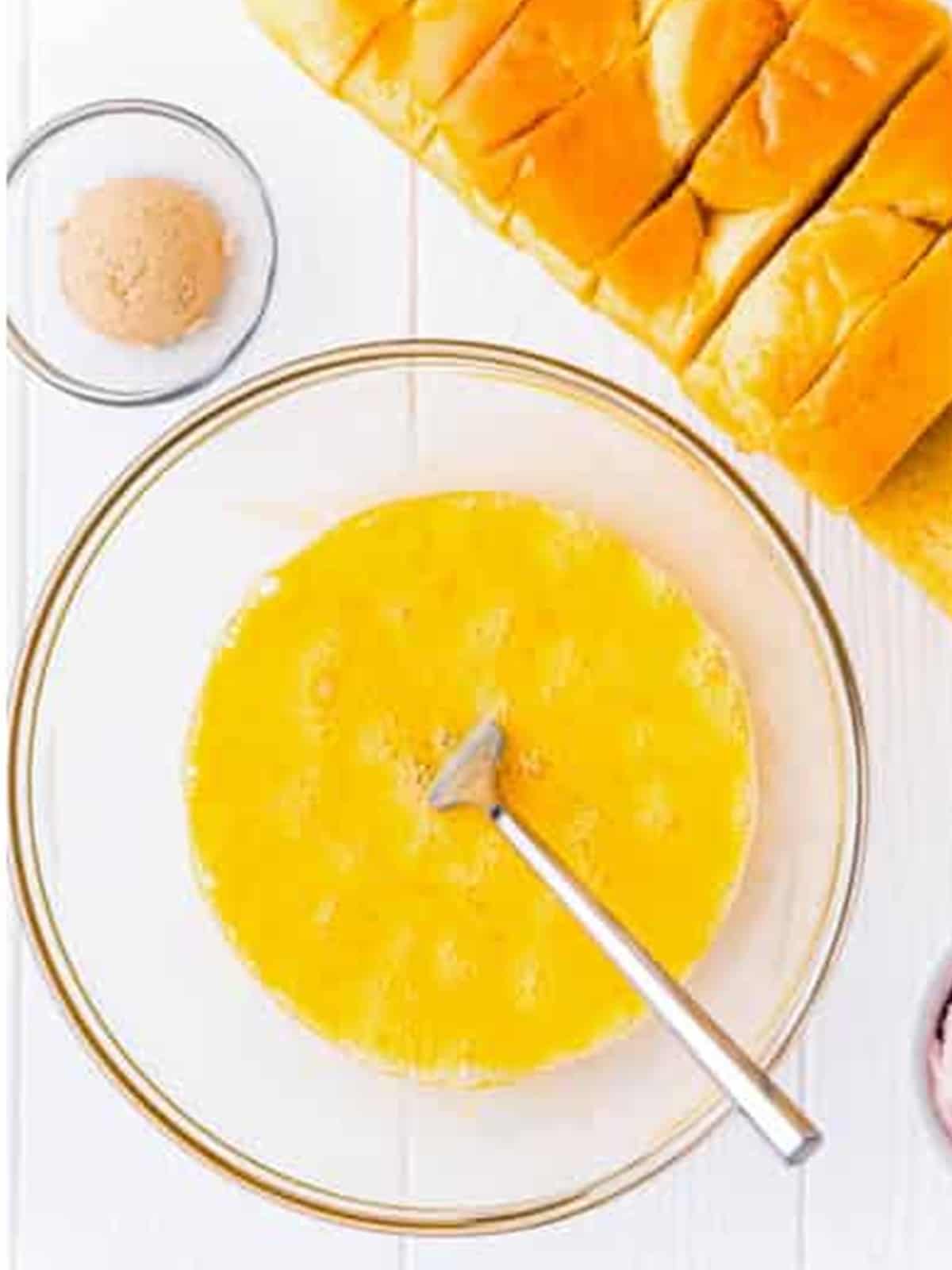 Beating eggs in a glass bowl for stuffed French toast custard.