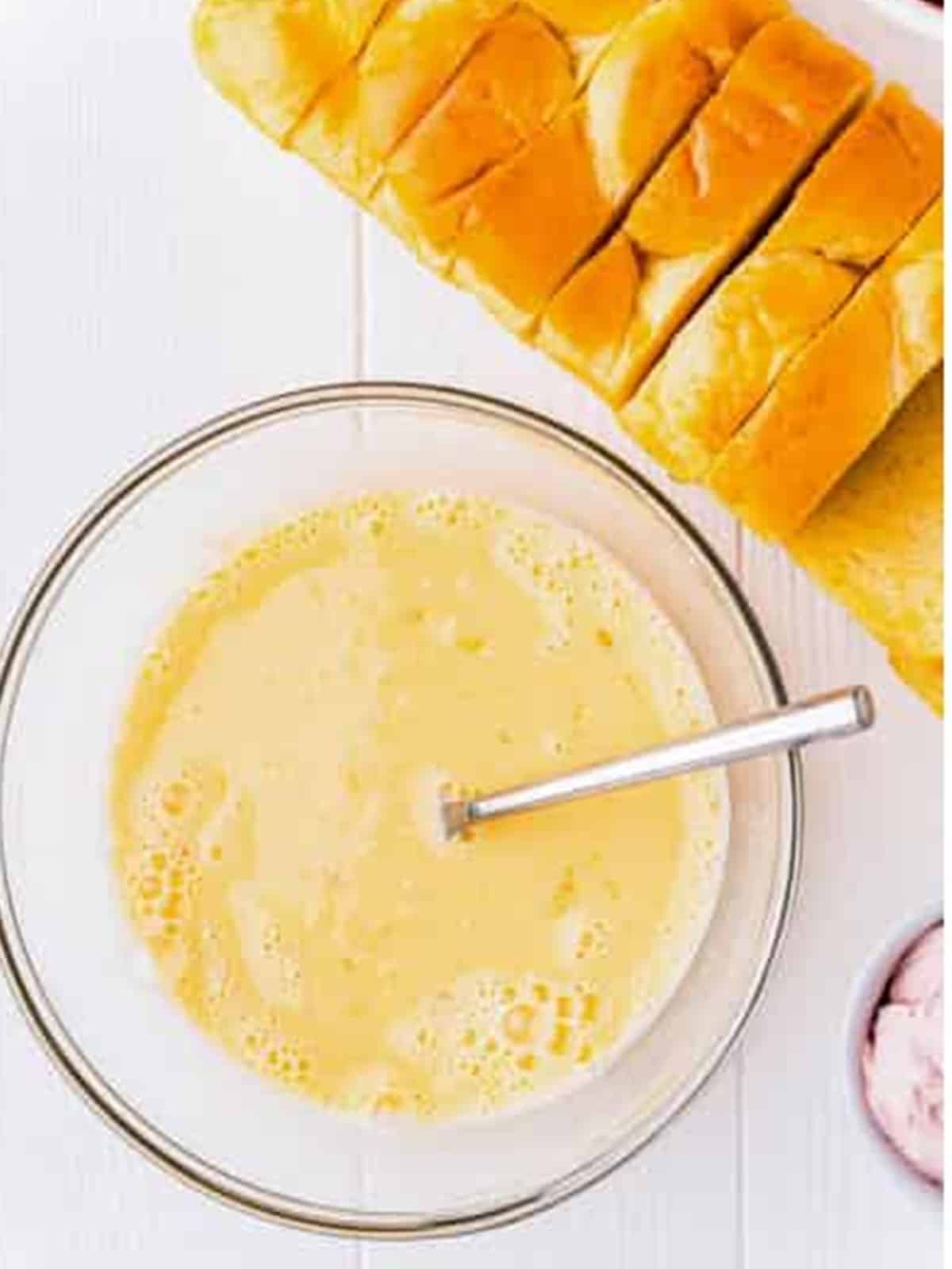 Smooth French toast custard whisked together in a glass bowl.