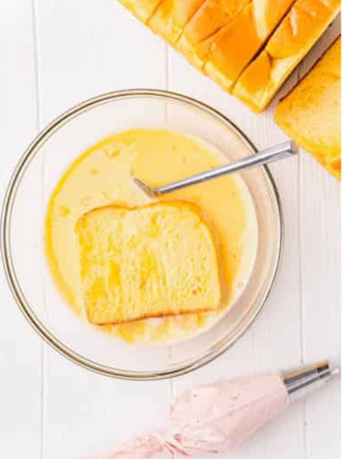 Dipping a stuffed brioche slice into the egg custard.