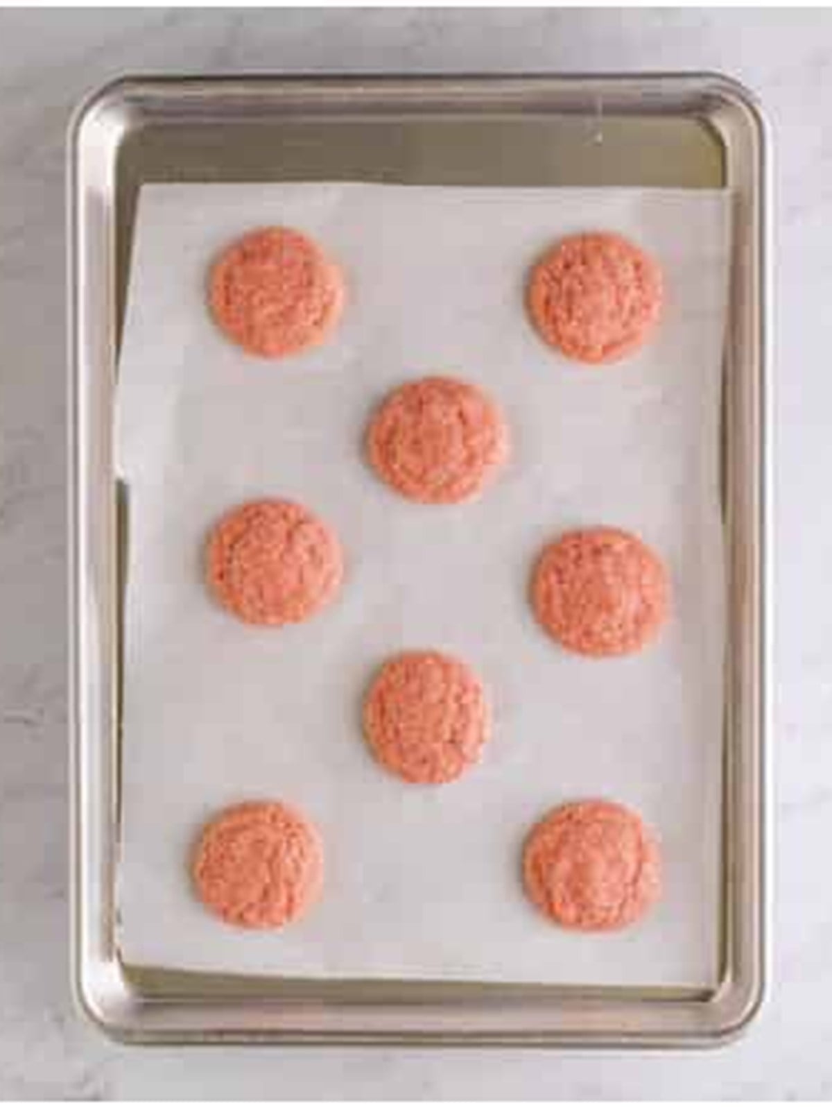 Baked Strawberry Cookies cooling on a parchment-lined tray.