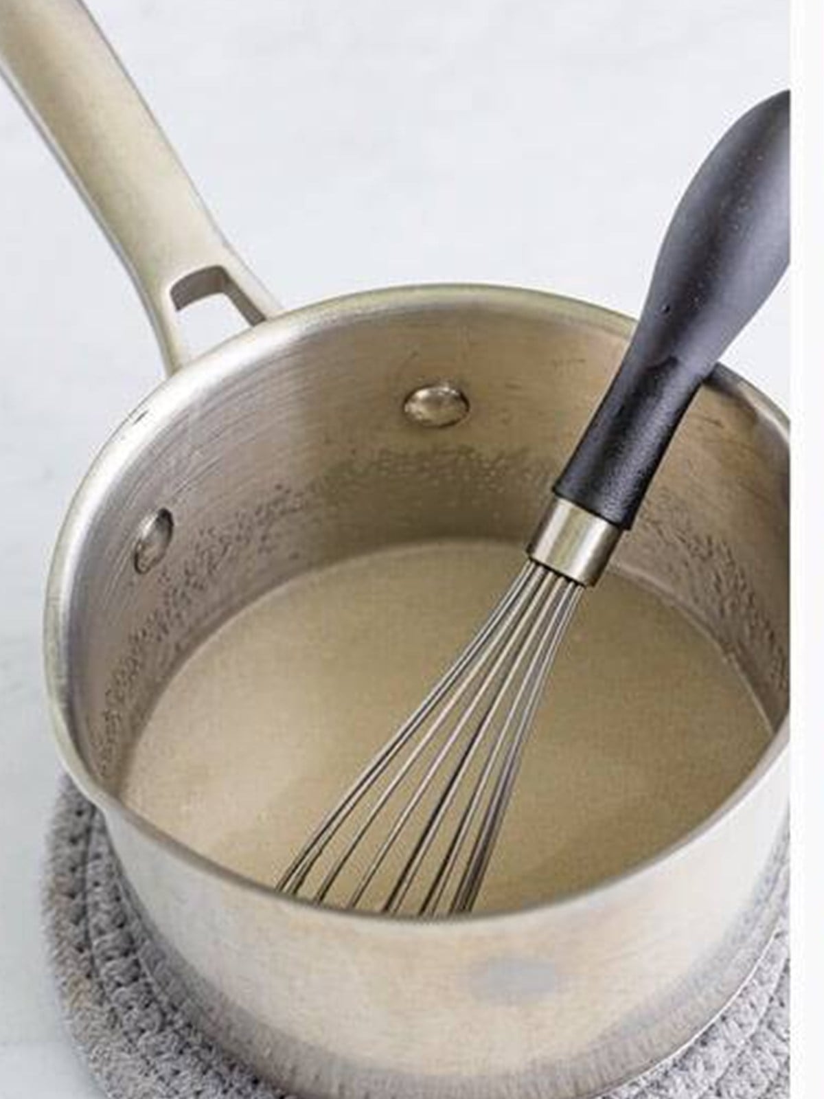 Boiling water and fruit pectin in a saucepan for freezer jam.
