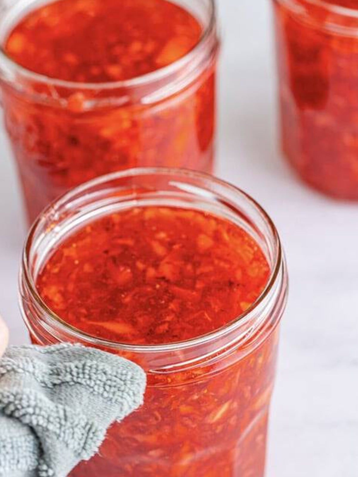 Strawberry freezer jam filled into glass jars.