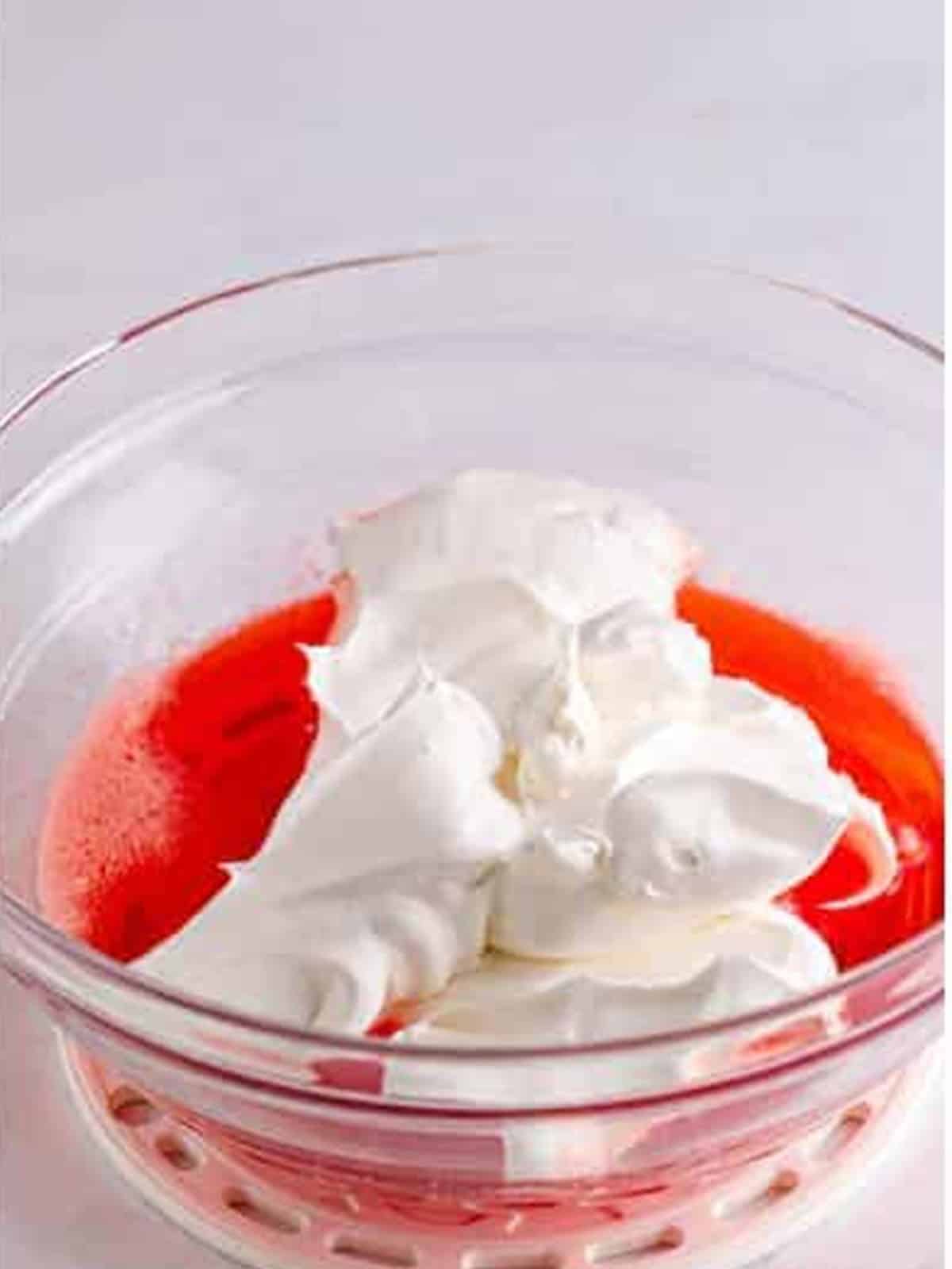 Whipped topping folded into the strawberry jello mixture.