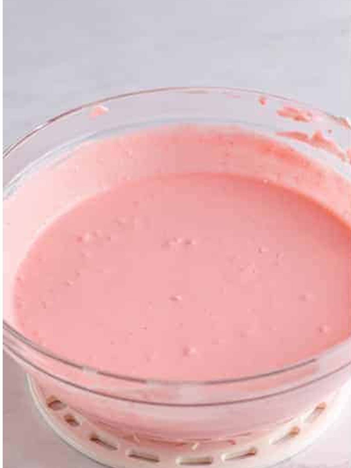Thickened pink strawberry jello pie filling in a bowl.